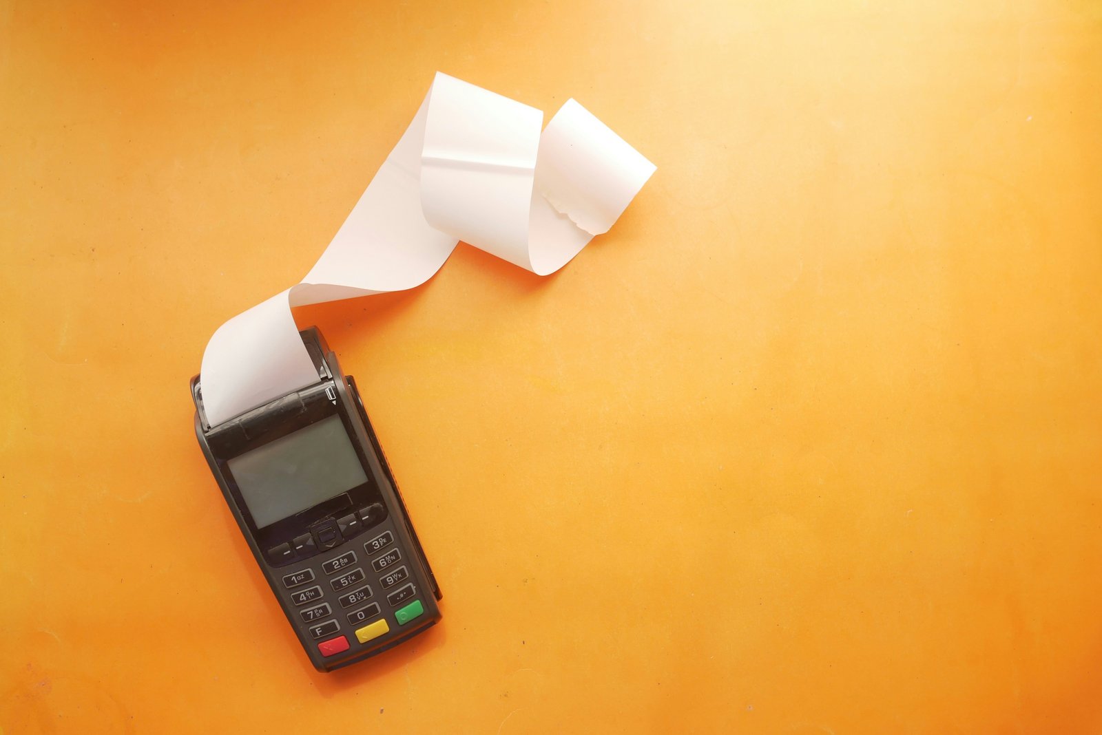 Datafono expulsando papel por cometer varios gastos hormiga